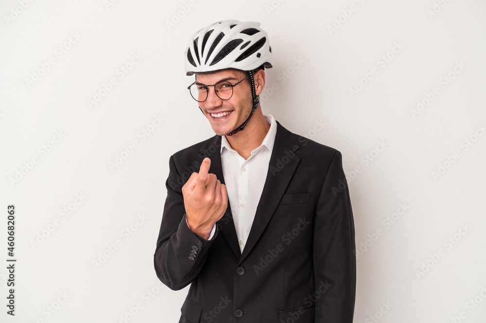 Young business caucasian man holding bike helmet isolated on white background pointing with finger at you as if inviting come closer. Young business caucasian man holding bike helmet isolated on white background pointing with finger at you as if inviting come closer.
