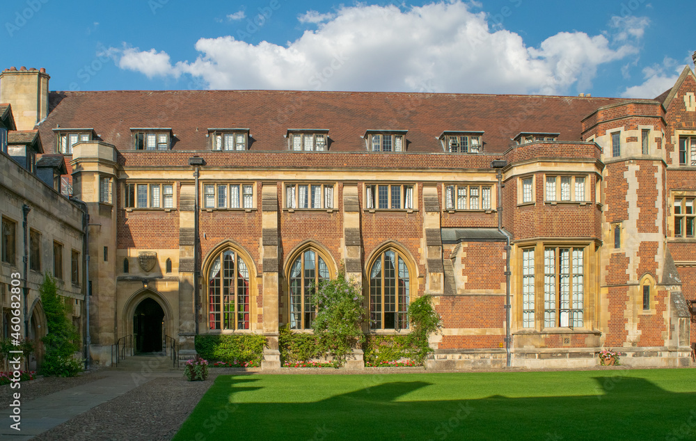 Facade of Historical bricked Christ's College Court with ornate Entrance and medieval windows in front of lawn at Cambridge England