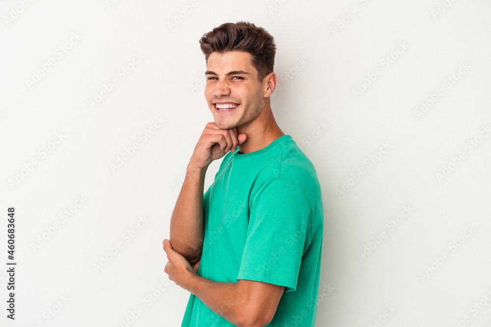 Young caucasian man isolated on white background smiling happy and confident, touching chin with hand. Young caucasian man isolated on white background smiling happy and confident, touching chin with hand.