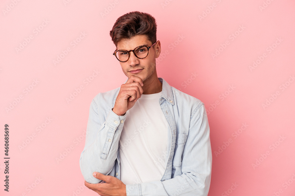 Young caucasian man isolated on pink background thinking and looking up, being reflective, contemplating, having a fantasy. Young caucasian man isolated on pink background thinking and looking up, being reflective, contemplating, having a fantasy.