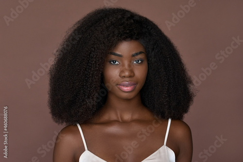 Gorgeous attractive adult young 20s African American girl with afro hairstyle looking at camera isolated on brown background. Headshot close up front portrait. Beauty skincare cosmetology concept. photo