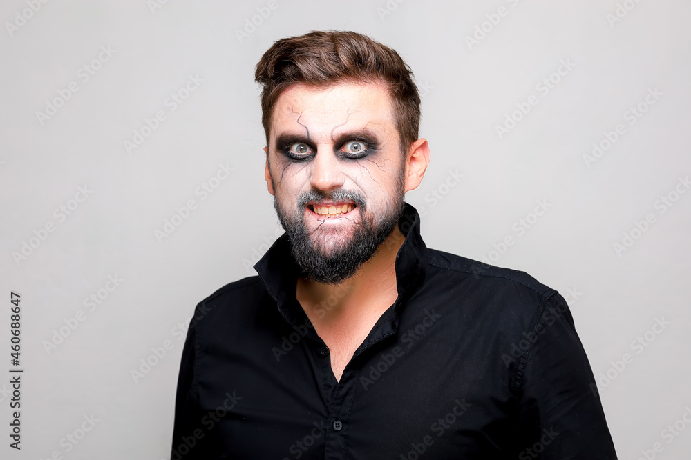 undead makeup for October 31 on a bearded man who shows teeth undead makeup for October 31 on a bearded man who shows teeth
