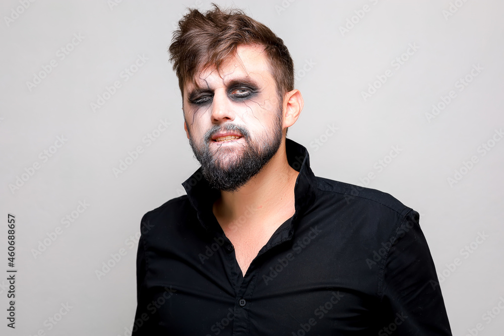 Obraz premium undead makeup for October 31 on a bearded man who shows teeth