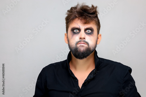 portrait of a man standing on a white background with undead-style makeup for All Saints Halloween