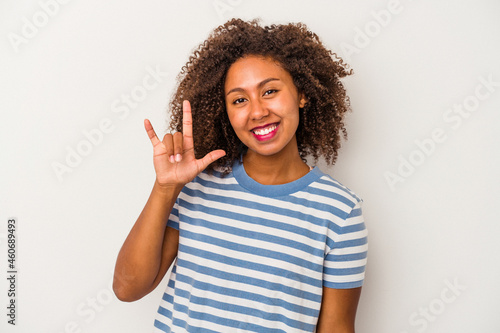 Young african american woman with curly hair isolated on white background showing a horns gesture as a revolution concept Fototapeta
