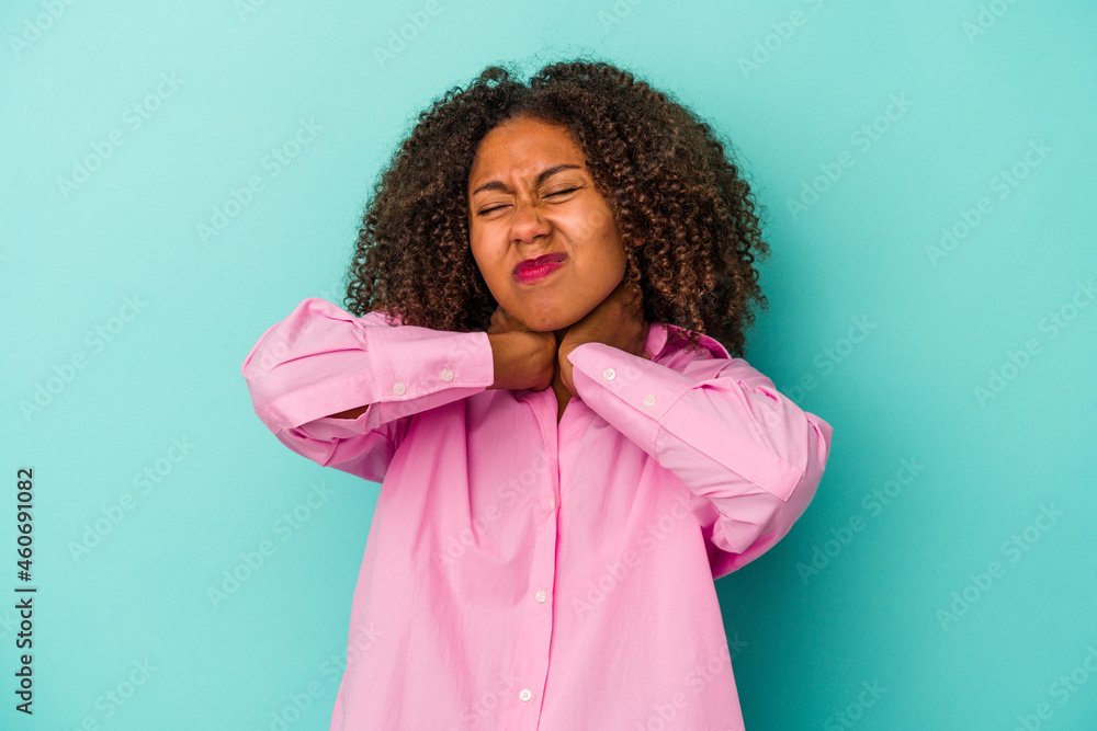 Young african american woman with curly hair isolated on blue background suffering neck pain due to sedentary lifestyle. Young african american woman with curly hair isolated on blue background suffering neck pain due to sedentary lifestyle.