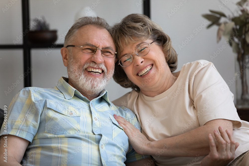 Happy old mature bonding married couple laughing at funny joke, enjoying pleasant conversation. Joyful middle aged retired man woman spending time together at home, good family relations concept. Happy old mature bonding married couple laughing at funny joke, enjoying pleasant conversation. Joyful middle aged retired man woman spending time together at home, good family relations concept.