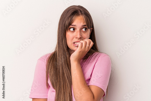 Young caucasian woman isolated on white background biting fingernails, nervous and very anxious.