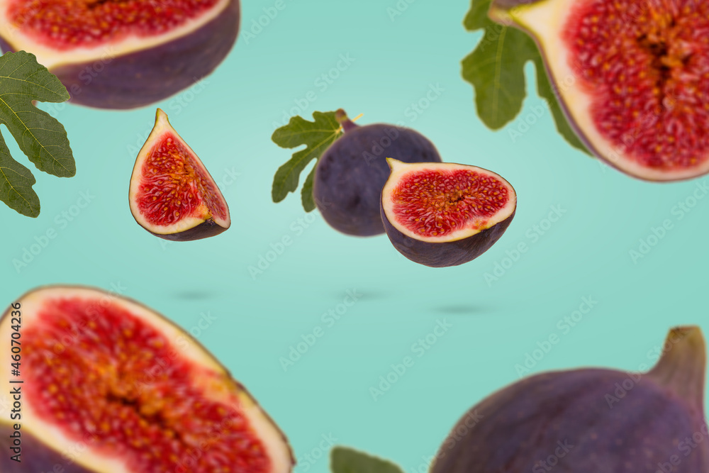 Trendy minimal food concept with fresh ripe whole and sliced figs flying in air isolated on pastel green background. Trendy minimal food concept with fresh ripe whole and sliced figs flying in air isolated on pastel green background.