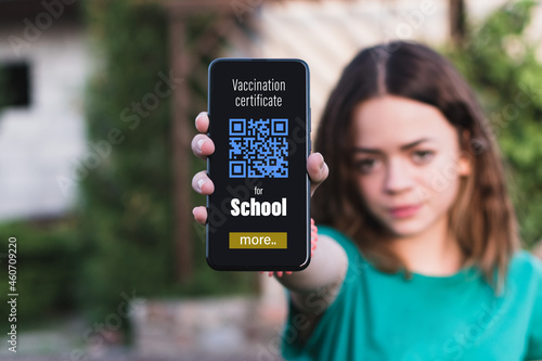 A young girl shows the qr code of her vaccine