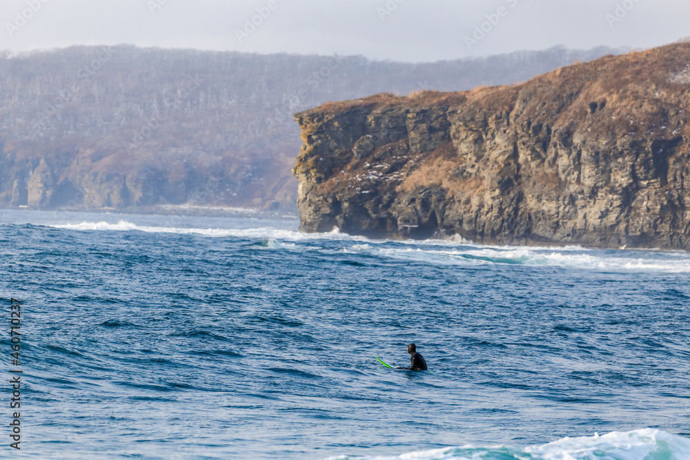 Obraz premium Surfers ride the waves in Vladivostok in winter.