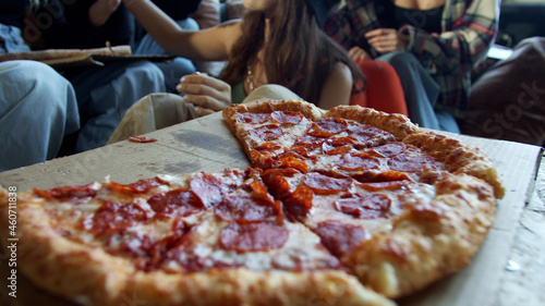 Young hipsters are sharing pepperoni pizza in a dance studio 