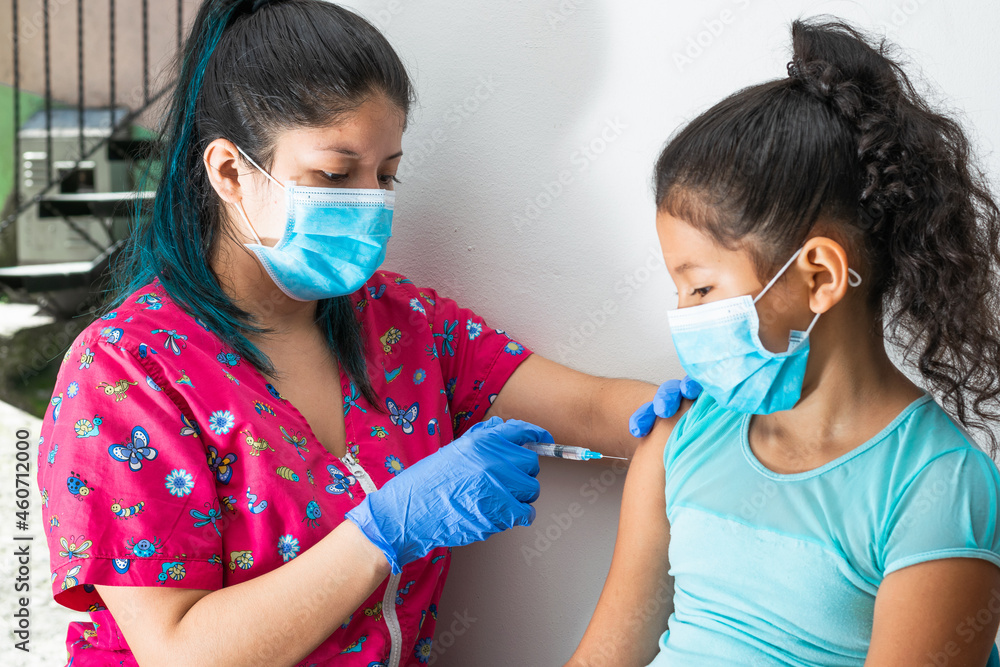 children's nurse injecting brown girl's arm. home-to-home vaccination plan, doctor's hand with rubber gloves injecting covid-19 vaccine. flu vaccine. medical concept, health and pandemic.