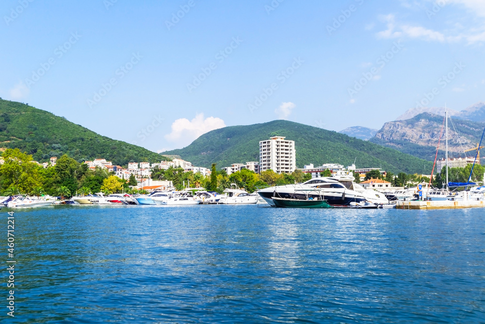 Close-up shot of the city of Budva from a yacht, in the background a mountain range with vegetation. Travel along the coast of Montenegro.