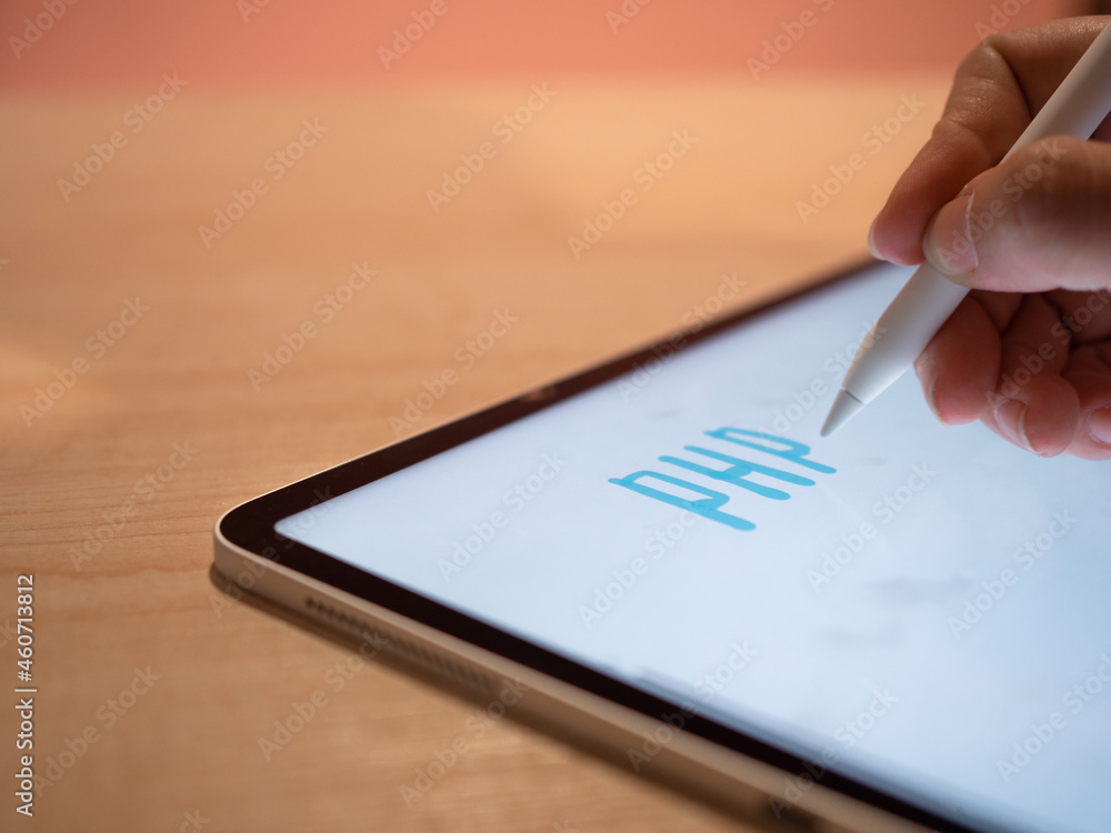 PHP Programming languages, concept. The hand makes an inscription on the tablet screen using a stylus, close-up small depth of field PHP Programming languages, concept. The hand makes an inscription on the tablet screen using a stylus, close-up small depth of field