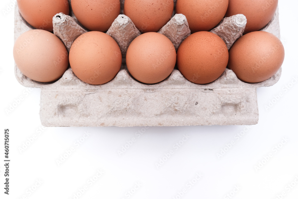 Ten brown chicken eggs in a carton box, container on white background with copy space Ten brown chicken eggs in a carton box, container on white background with copy space