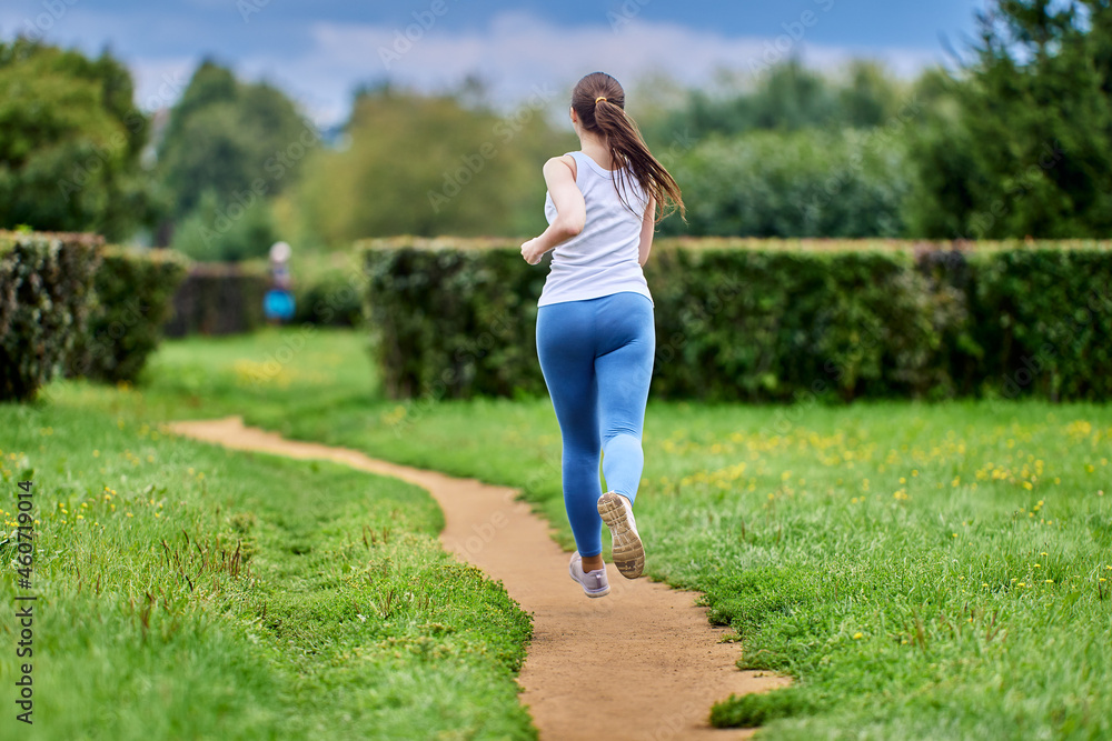 Rear view of woman who is coaching in park in sportswear. Rear view of woman who is coaching in park in sportswear.