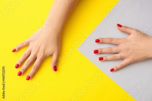 Female hands with beautiful manicure on yellow background  closeup