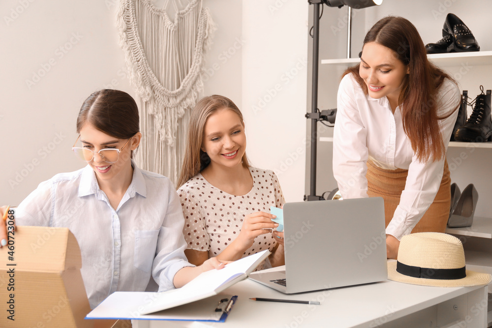 Female business owner and sellers working in modern shop Female business owner and sellers working in modern shop
