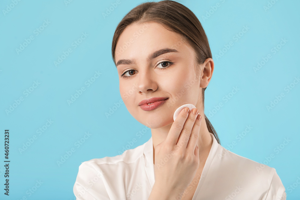 Beautiful young woman with cotton pad on color background Beautiful young woman with cotton pad on color background