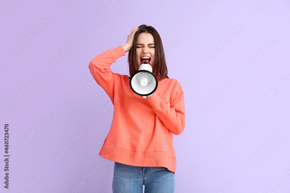 Obraz premium Protesting young woman with megaphone on color background