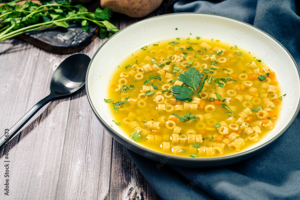Minced view of an exquisite chicken and vegetable soup with small noodles and parsley. Natural and healthy food concept Minced view of an exquisite chicken and vegetable soup with small noodles and parsley. Natural and healthy food concept