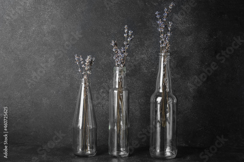 Vases with beautiful lavender flowers on dark background