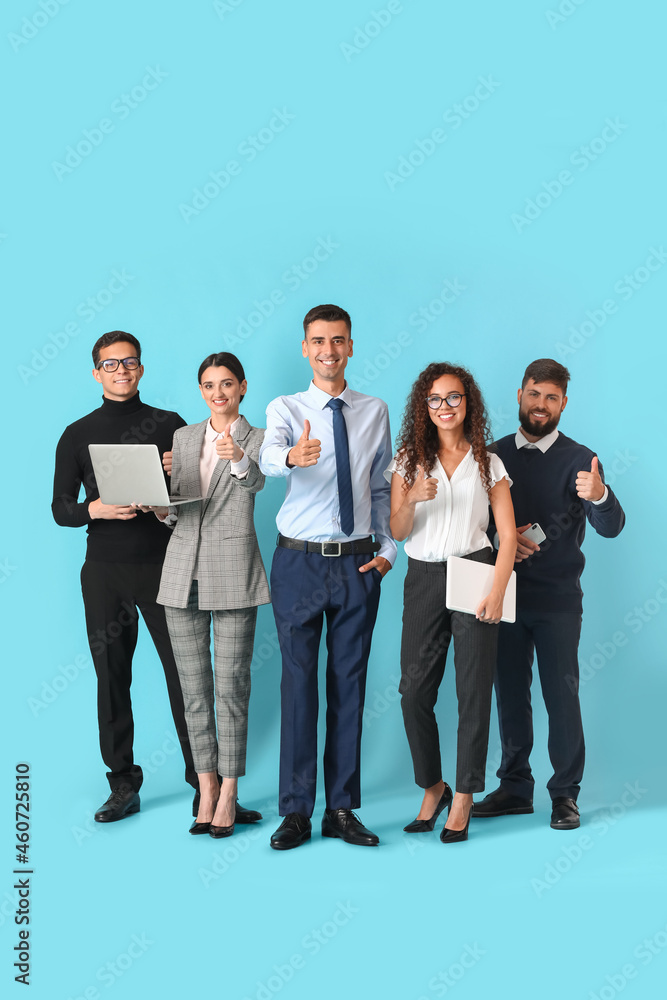 Team of young business people showing thumb-up on blue background Team of young business people showing thumb-up on blue background