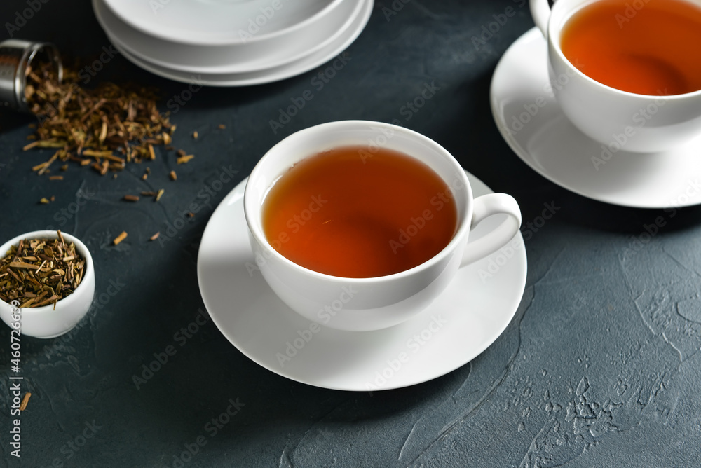 Cups of tasty hojicha green tea on black background Cups of tasty hojicha green tea on black background