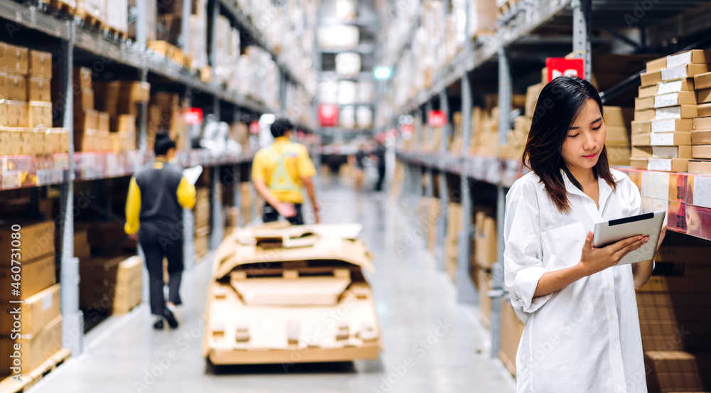 Portrait of asian woman standing and order details on tablet for checking goods and supplies on shelves store at factory with goods background in distribution industry warehouse.logistic and business