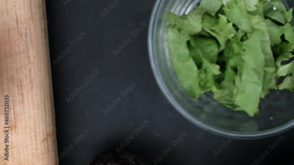 Bowls of chopped avocado, lettuce, and tortilla chips on black surface Bowls of chopped avocado, lettuce, and tortilla chips on black surface