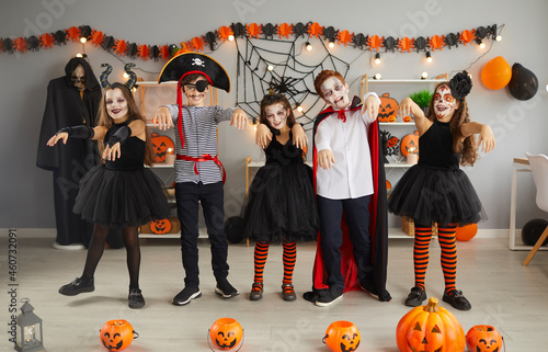 Foto Group of children having fun and doing zombie dance at Halloween party at home