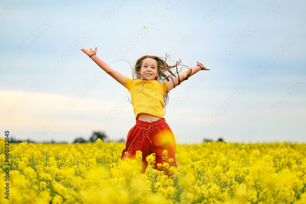 Pretty long haired girl playing in vibrant canola field in full bloom Pretty long haired girl playing in vibrant canola field in full bloom
