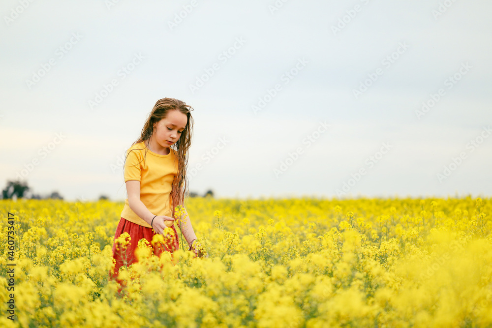 Pretty long haired girl playing in vibrant canola field in full bloom Pretty long haired girl playing in vibrant canola field in full bloom