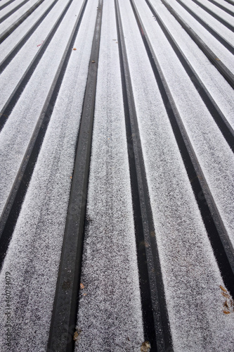 In winter, after snow, the colored steel tiles on the roof are covered with snow texture background