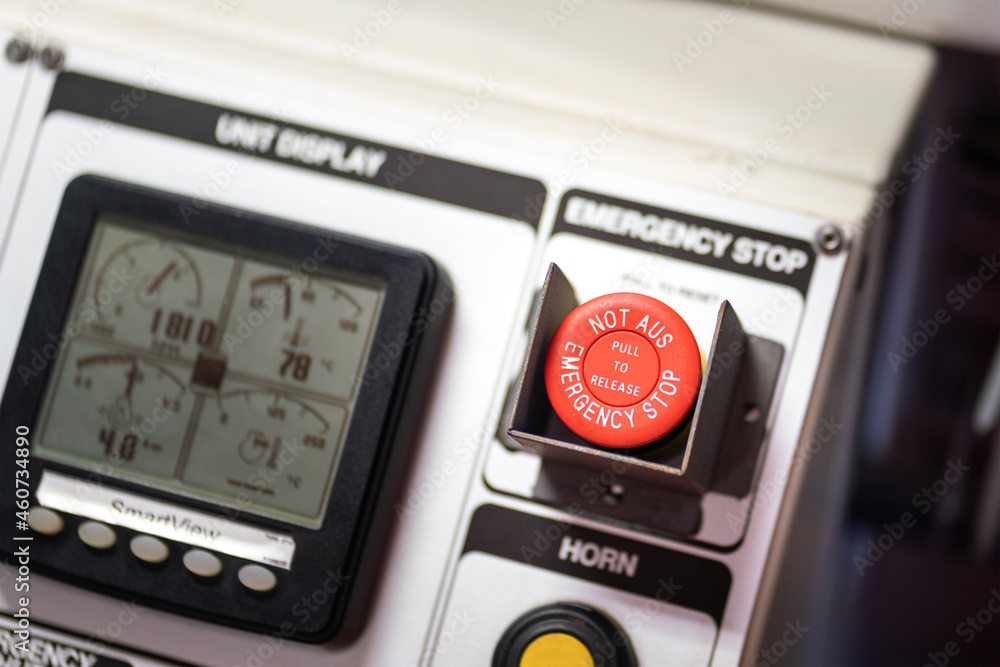 An emergency stop button in red color on the control panel of ...