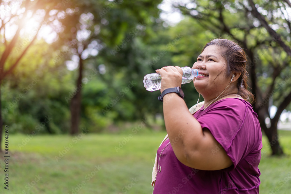 Asian fat woman drinking water bottle with workout outdoors exercising in park, Sport and recreation for weight loss idea concept. Asian fat woman drinking water bottle with workout outdoors exercising in park, Sport and recreation for weight loss idea concept.