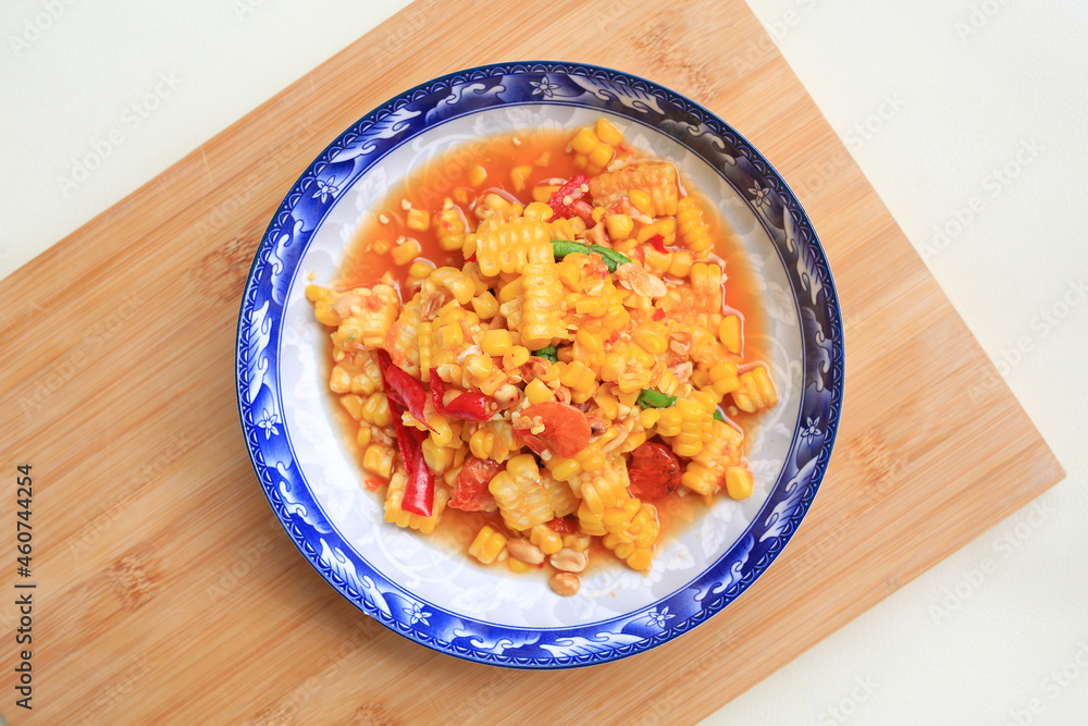 Thai style chili and lime corn salad in plate against wooden board. Spicy vegetable salads. Top view Thai style chili and lime corn salad in plate against wooden board. Spicy vegetable salads. Top view