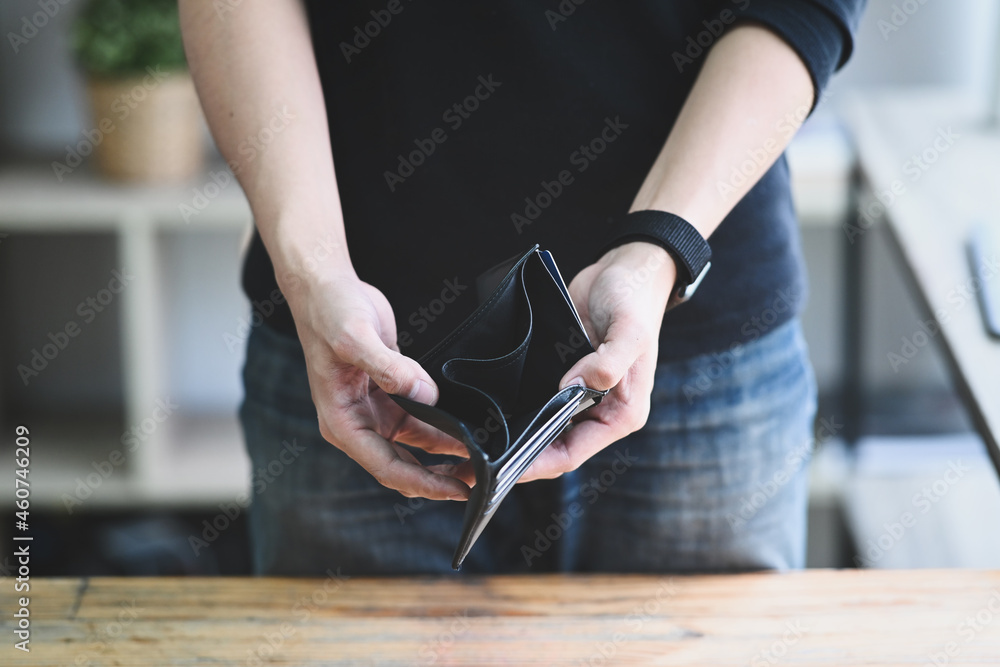 Man holding empty wallet. Bankruptcy, unemployment and financial crisis concept. - obrazy, fototapety, plakaty 