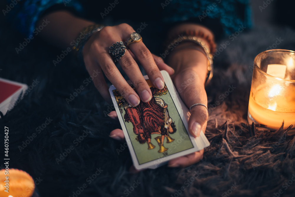 Fortune teller holding tarot cards deck. tarot cards and burning candles. Astrologists and forecasting concept. - obrazy, fototapety, plakaty 