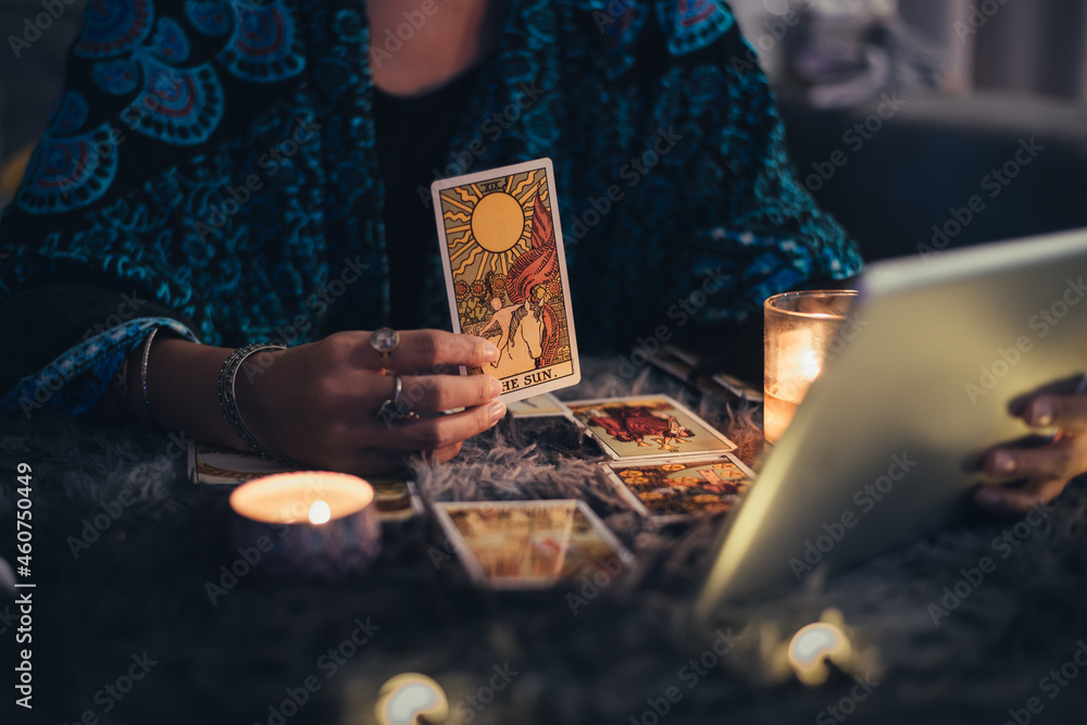 Fortune teller showing tarot cards online. Online tarot cards with tablet or smartphone. Astrologists and horoscope online concept. - obrazy, fototapety, plakaty 