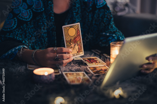 Fortune teller showing tarot cards online. Online tarot cards with tablet or smartphone. Astrologists and horoscope online concept. photo