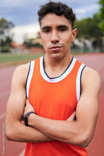 Young latin athlete with brown skin, half body portrait in a sports car, out of focus background.