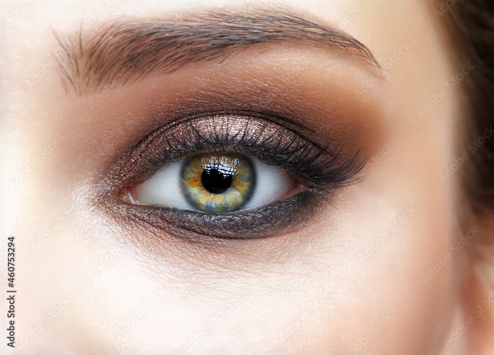 Obraz premium Closeup macro shot of human female eye with pink eyes shadows