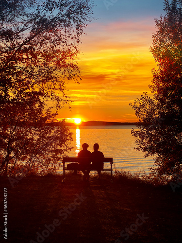 Couple sitting on a bench in summer sunset