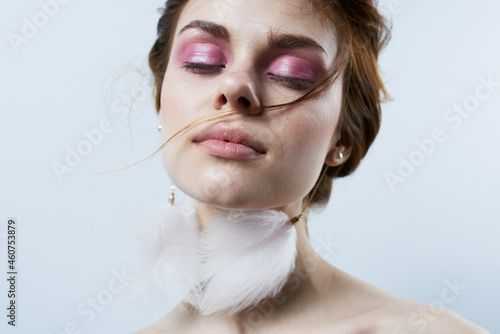cheerful woman with bare shoulders fluffy earrings bright makeup