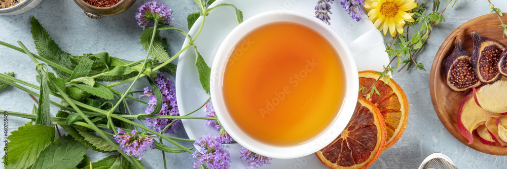 Tea panorama with herbs, flowers and fruit, shot from above. Healthy hot drink panoramic banner with orange Tea panorama with herbs, flowers and fruit, shot from above. Healthy hot drink panoramic banner with orange