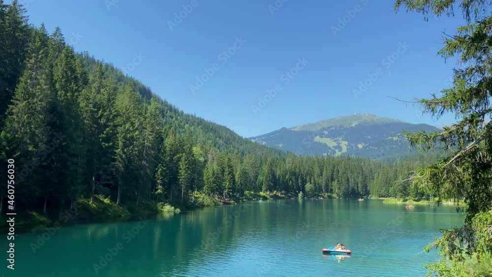 Lake Cauma in Flims, Canton of Grisons in Switzerland. A Trent boat with a family is sailing across the lake. A very famous and popular destination in Switzerland Lake Cauma in Flims, Canton of Grisons in Switzerland. A Trent boat with a family is sailing across the lake. A very famous and popular destination in Switzerland