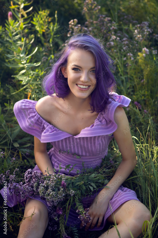 teenage girl with dyed purple hair and a nose piercing in the grass with a bouquet teenage girl with dyed purple hair and a nose piercing in the grass with a bouquet