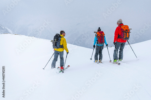 Ski-Alpinisten bei der gemeinsamen Abfahrt im freien Gelände bei schlechter Sicht